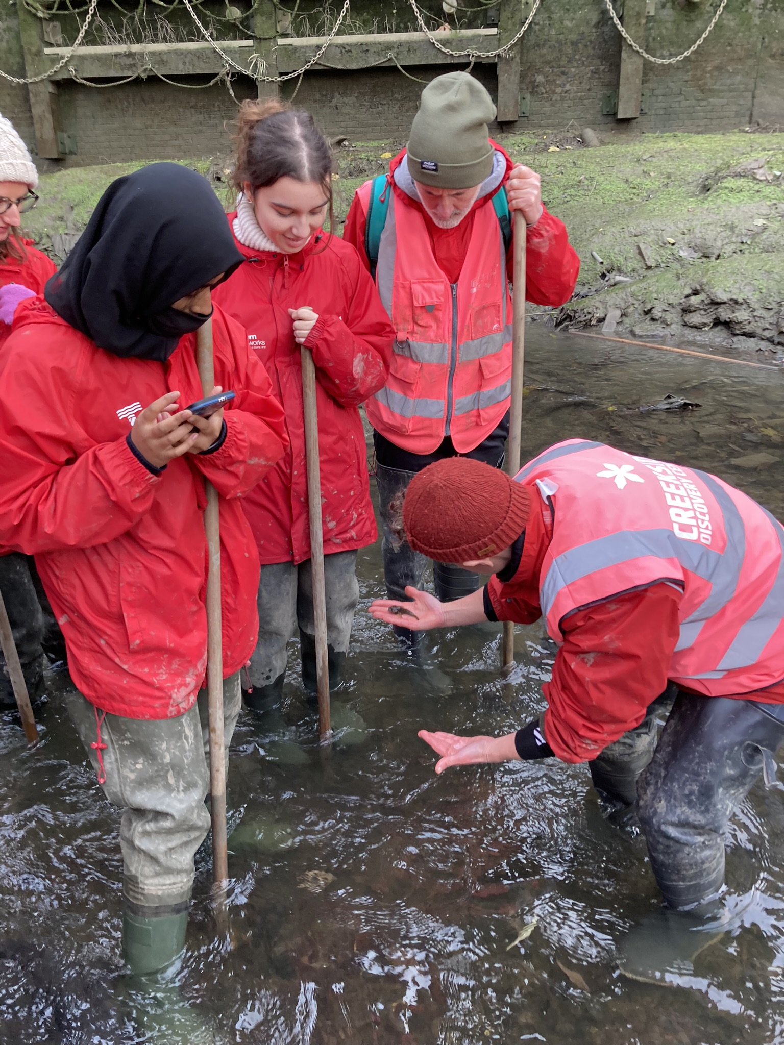 A volunteer working with a group at Creekside