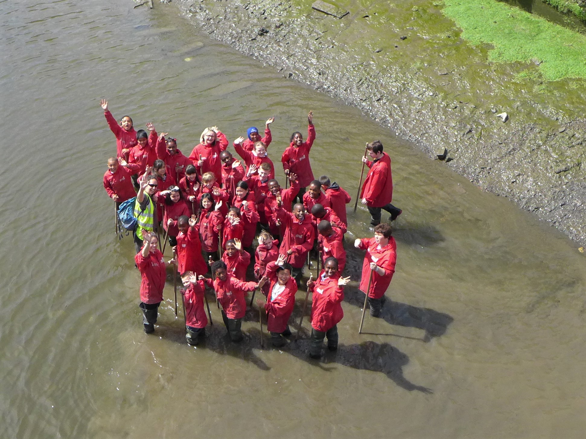 A group in Deptford Creek, waving to camera